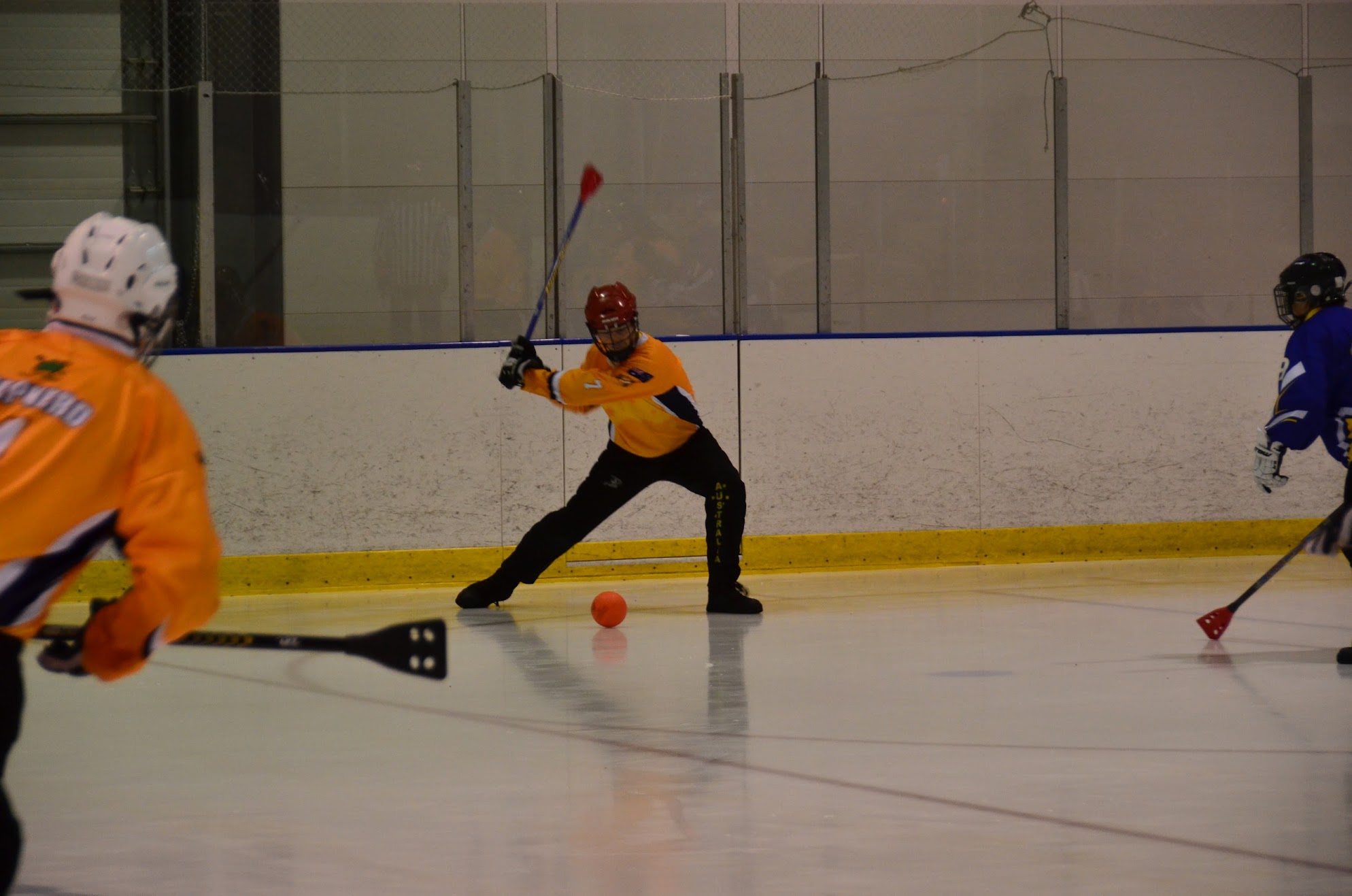 Australian player winding up to shoot on an indoor rink